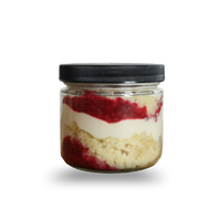 Layered dessert in a glass jar with a black lid on a white background
