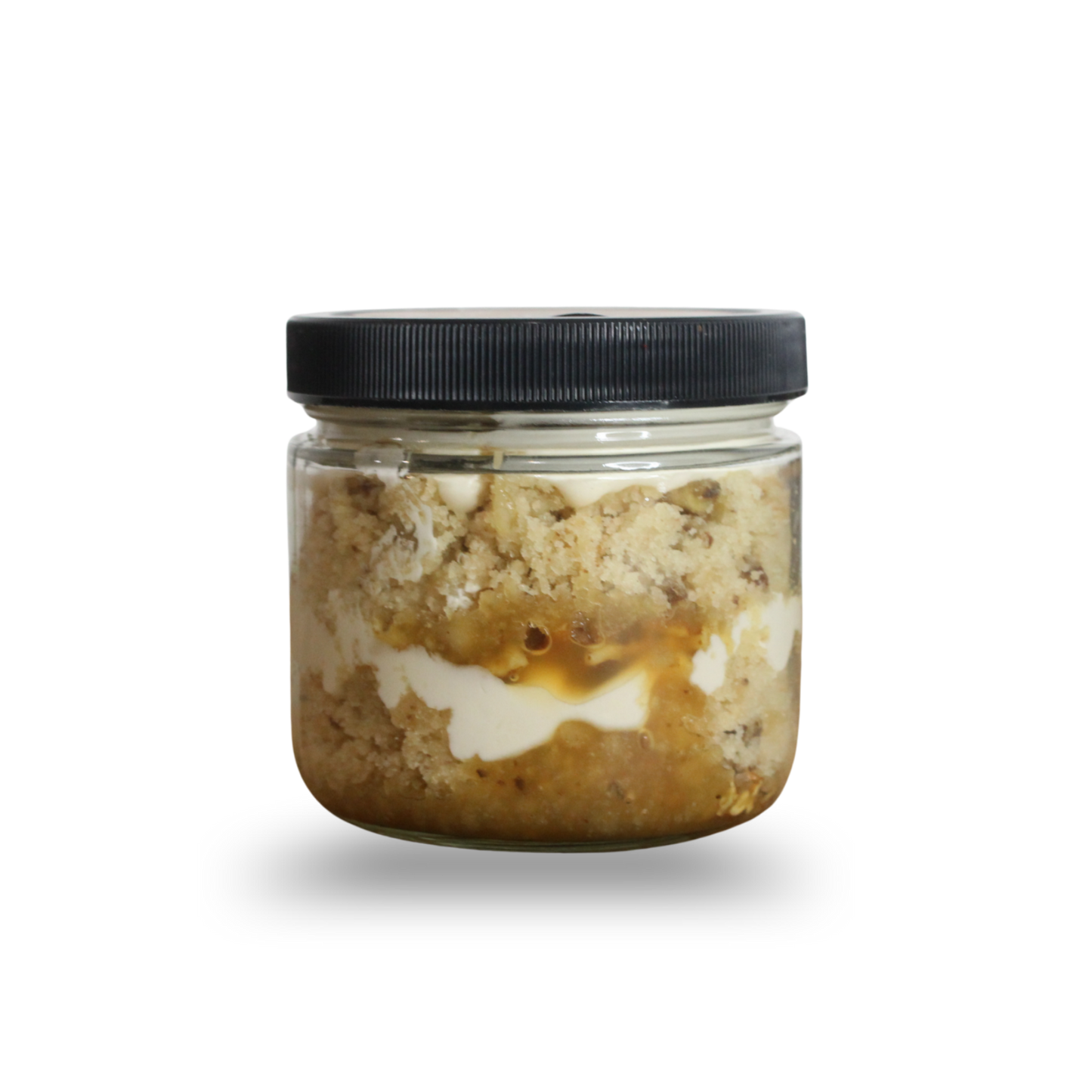 Jar of layered dessert with a black lid on a white background